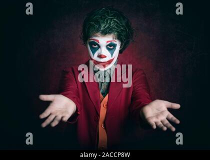boy dressed as Joker on dark background Stock Photo