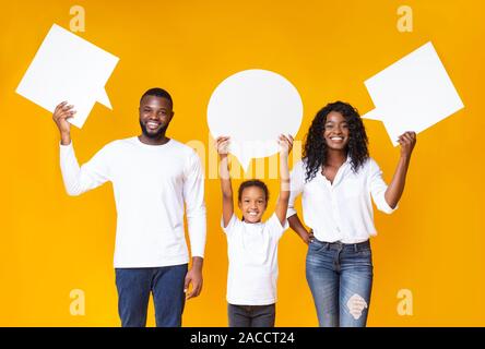 Empty speech bubbles in hands of smiling african american family Stock Photo