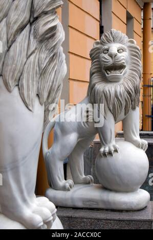 Funny marble smiling lion with ball statue in front of the Chinese restaurant Stock Photo