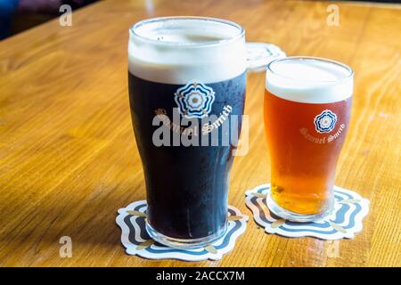 A pint of Samuel Smith's Extra stout and half-pint of best bitter on a bar, Stockton on Tees, County Durham Stock Photo