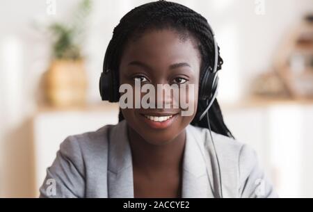 Portrait of black smiling female call center operator in headset Stock Photo