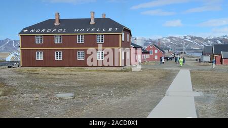 Tourists exploring Ny Alesund beside the North Pole hotel, the world's most northerly hotel. Stock Photo