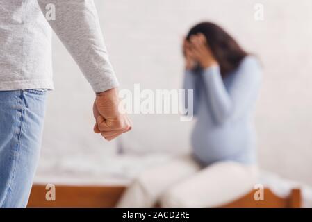 Scared pregnant lady suffering from domestic violence of her husband Stock Photo