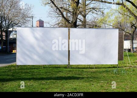 two realistic empty billboards side by side on urban roadside greenery Stock Photo