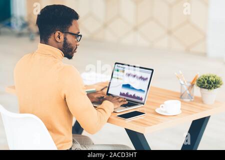 Black manager working with diagrams on pc Stock Photo