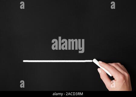 female hand drawing chalk line on chalkboard - blackboard background with copy space Stock Photo
