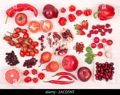 Red fruits and vegetables on a white wooden table, top view Stock Photo