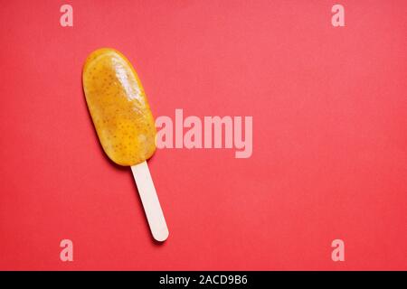 passion fruit or maracuya popsicle or ice lolly or ice pop on red background with copy space Stock Photo