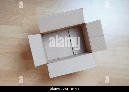 topview of empty cardboard box on laminate floor Stock Photo