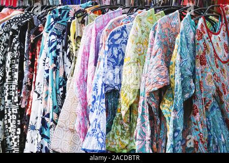 clothes rack with boho hippie style floral pattern women's clothing at outdoor fashion market Stock Photo