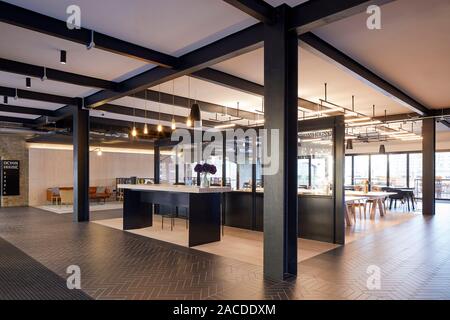 Informal meeting areas with communal tables. Devon House, London, United Kingdom. Architect: Stiff + Trevillion Architects, 2019. Stock Photo