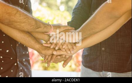 Concept of Friendship, support and teamwork People joining hands together - Young people holding hands together at outdoor. Stock Photo