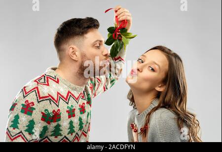 happy couple kissing under the mistletoe Stock Photo