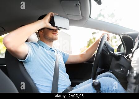 man or driver wearing vr glasses and driving car Stock Photo