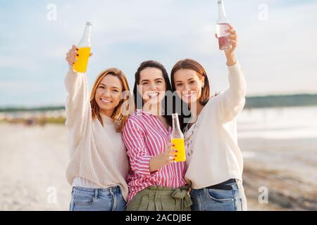 young women toasting non alcoholic drinks on beach Stock Photo