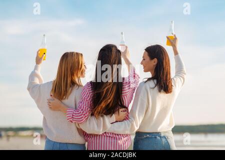 young women toasting non alcoholic drinks on beach Stock Photo