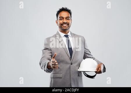 male architect in helmet giving hand for handshake Stock Photo