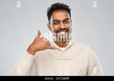 indian man in knitted sweater over gray background Stock Photo