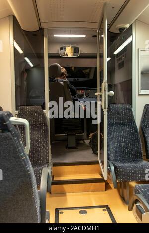 An empty corridor of night train on regional line with open door to control cabin. Local train with driver in cab. Stock Photo