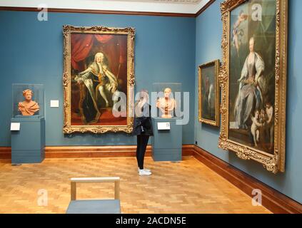 A woman studies 18th century paintings at the National Portrait Gallery, London, UK