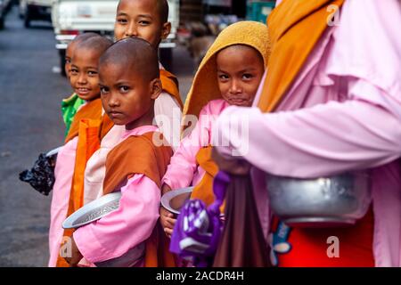 A Group Of Young Thilashin (Young Buddhist Nuns) Collecting Alms, Yangon, Myanmar. Stock Photo