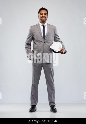 indian male architect with helmet over grey Stock Photo