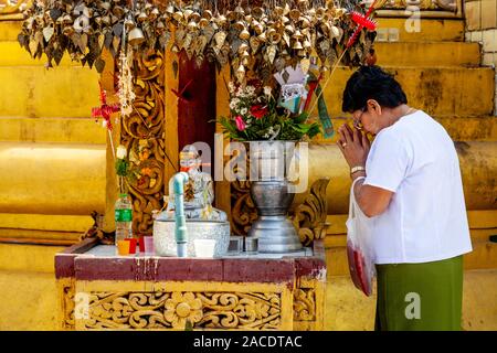 A Buddhist Woman Praying At The Sule Pagoda, Yangon, Myanmar. Stock Photo