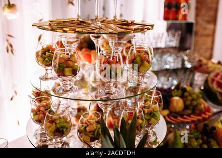 Fresh, exotic, organic fruits, light snacks in a plate on a buffet table. Assorted mini delicacies and snacks, restaurant food at event. Decorated del Stock Photo