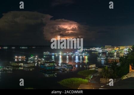 Lightning behind clouds at night, vivid town of Tefé on Lake Tefé, Amazona River, Amazon State, Northern Brasilia, Latin America Stock Photo