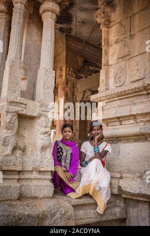 Hampi, Karnataka, INDIA - JANUARY 16, 2018: Portrait of Indian girls dressed in national dresses. Girls are sitting at the entrance to the ancient tem Stock Photo