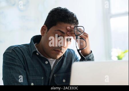 Stressed businessman working on laptop Stock Photo