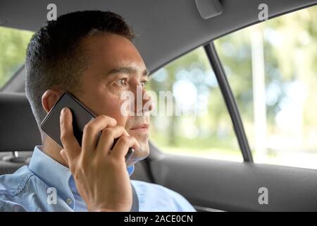 male passenger calling on smartphone in taxi car Stock Photo