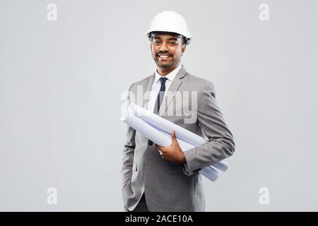 indian male architect in helmet with blueprints Stock Photo