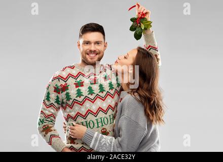 happy couple kissing under the mistletoe Stock Photo