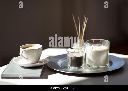 coffee, candles and aroma reed diffuser on table Stock Photo
