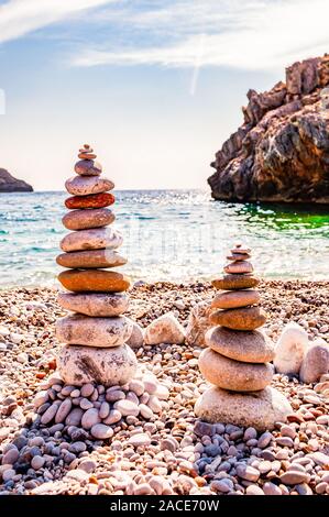 Two towers of flat stones on the beach. Rock balancing or stone stacking is the art discipline, or hobby in which rocks are naturally balanced on top Stock Photo