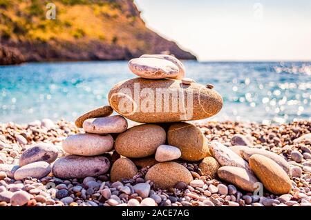 Abstract animal sculpture made of flat stones on the beach. Stone balancing is the art discipline, or hobby in which rocks naturally balanced on top o Stock Photo