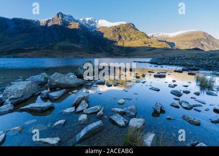 Early morning Cwm and lake, snow on mountain Y Garn.  Snowdonia national Park, Gwynedd, Wales, UK. Landscape, wide angle. Stock Photo