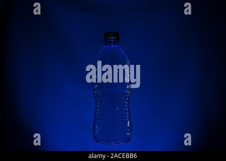Silhouette of used plastic bottle on dark background Stock Photo