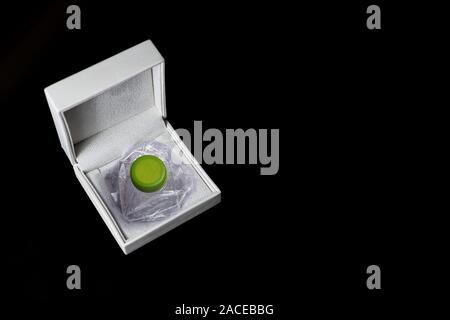 Crushed plastic bottle stored in a jewelry box on a black background Stock Photo