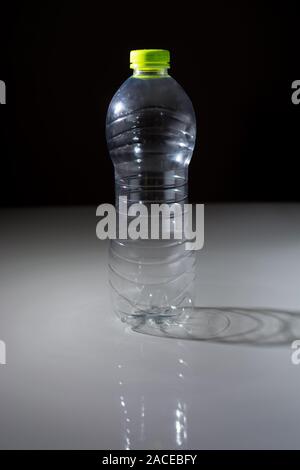 Empty plastic bottle in transparent PET on a dark background Stock Photo