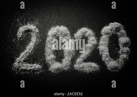 2020 shiny silver sparkles pattern on black table. Stock Photo