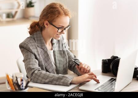Woman reporter working with laptop and camera Stock Photo