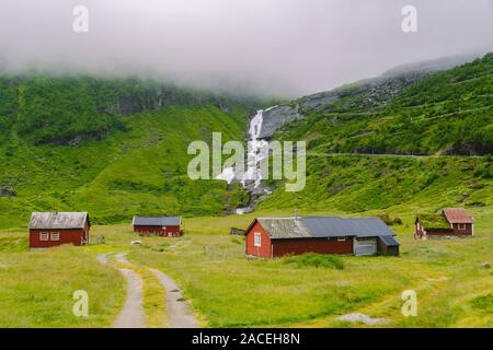 hut wooden mountain huts in mountain pass Norway. Norwegian landscape with typical scandinavian grass roof houses. Mountain village with small houses Stock Photo