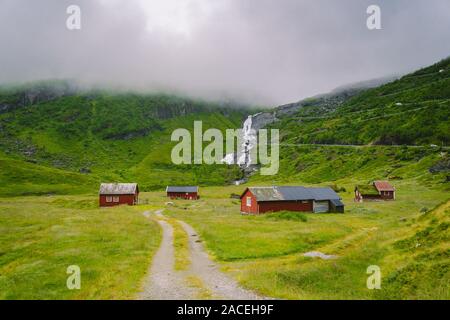 hut wooden mountain huts in mountain pass Norway. Norwegian landscape with typical scandinavian grass roof houses. Mountain village with small houses Stock Photo