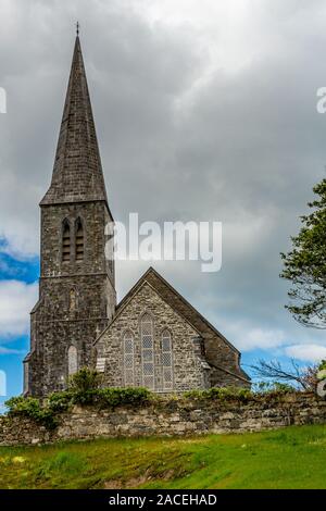 Christ church on a hill with its bell tower and surrounded by a stone fence, cloudy spring day in Clifden, province of Connacht, Ireland Stock Photo