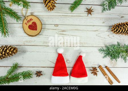Christmas frame background flat lay on white wood with other natural decoration and two santa hats . Stock Photo
