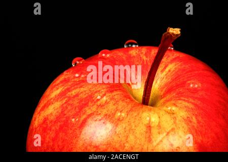 Red eating apple isolated on a black background with water drops Stock Photo