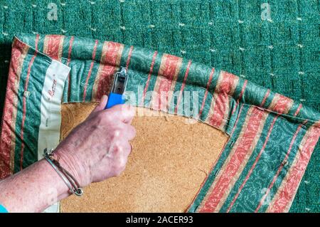 1 of 4 - Recovering an old dining chair - using a destapler to remove the existing seat cover. Search UIDIY2 for sequence. Stock Photo