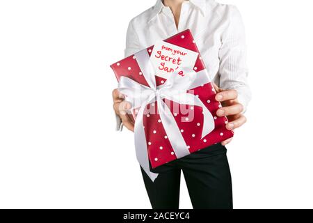 Secret Santa concept - female in office clothes holding wrapped present red background Stock Photo